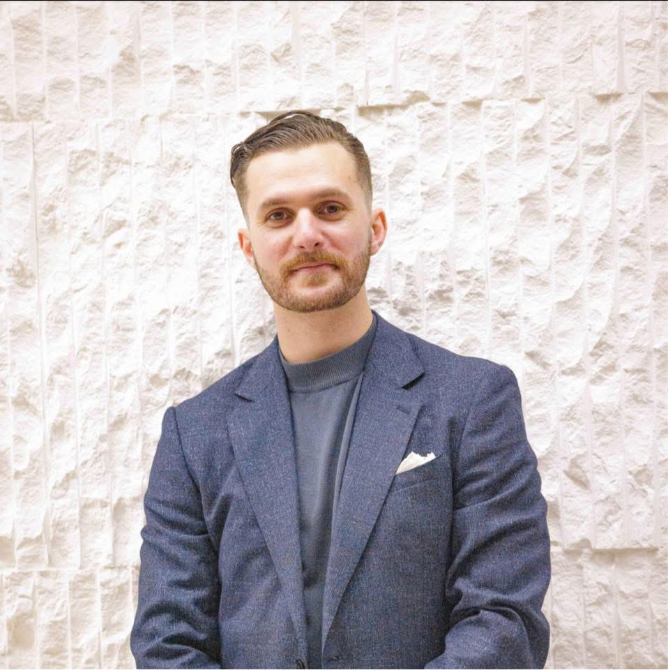 Victor Smargiasso in a blazer against a pale stone wall
