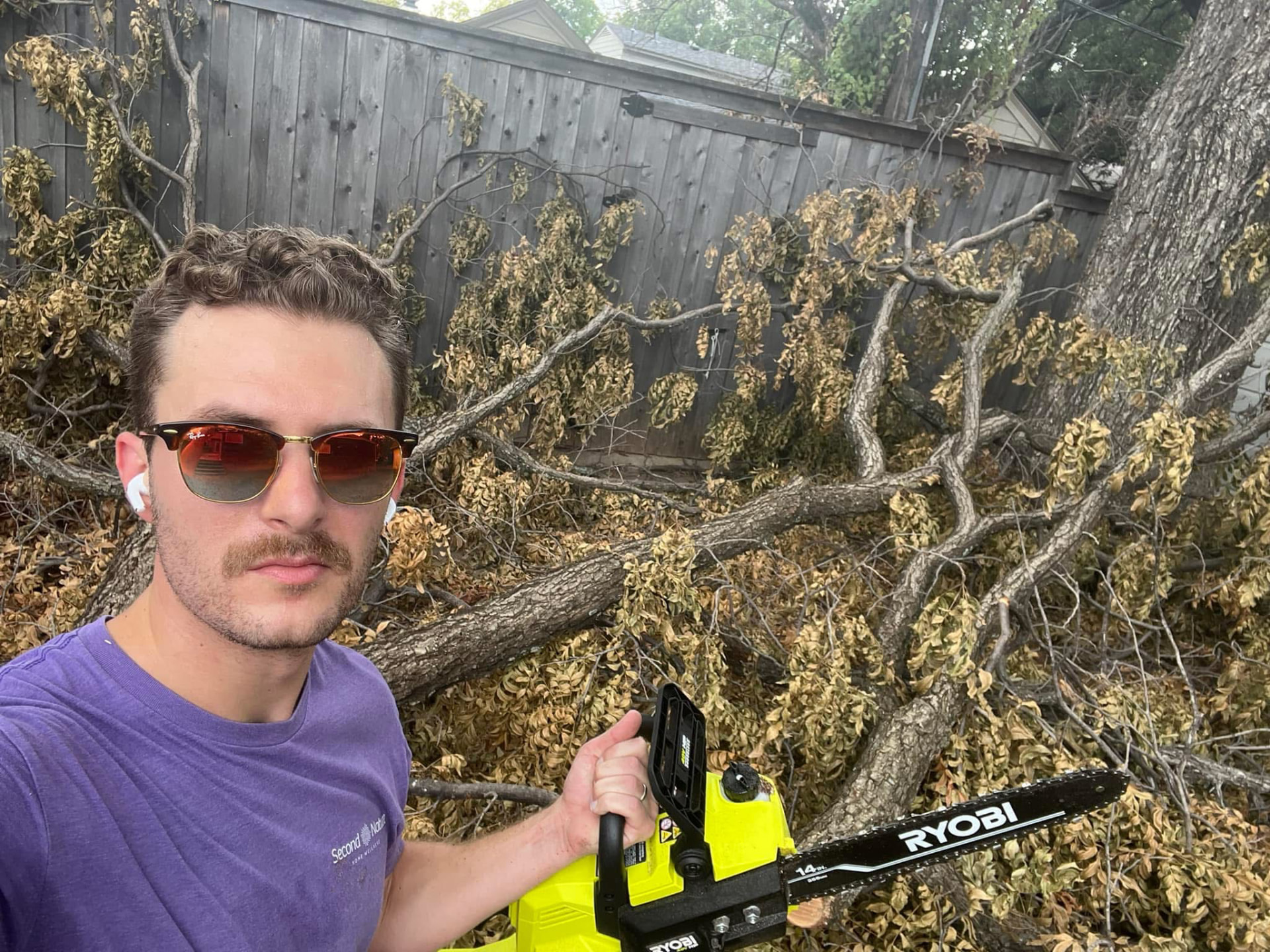 Victor Smargiasso in sunglasses holding a chainsaw in a backyard