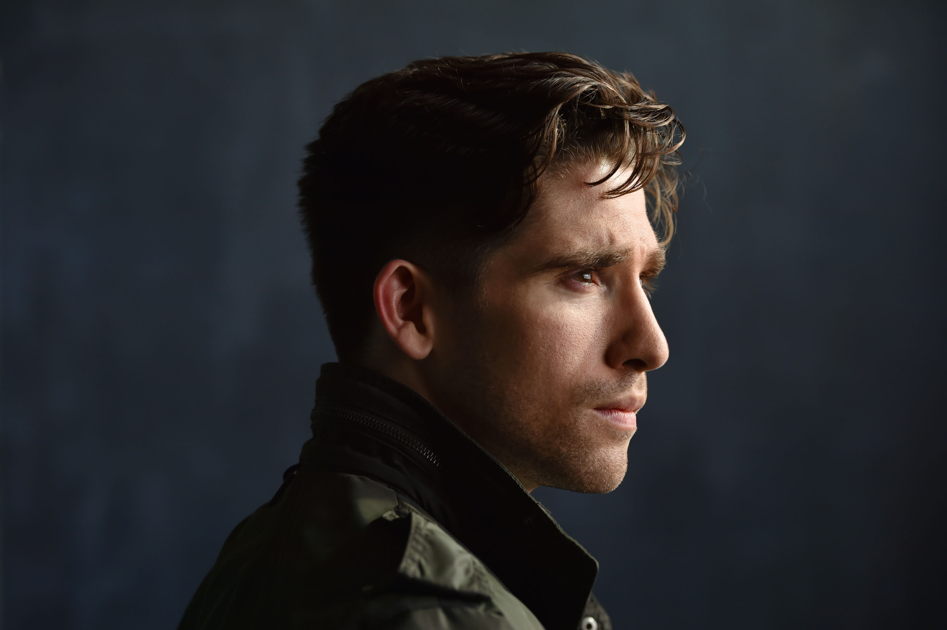 Dramatic profile headshot of Mark Laird against a dark backdrop