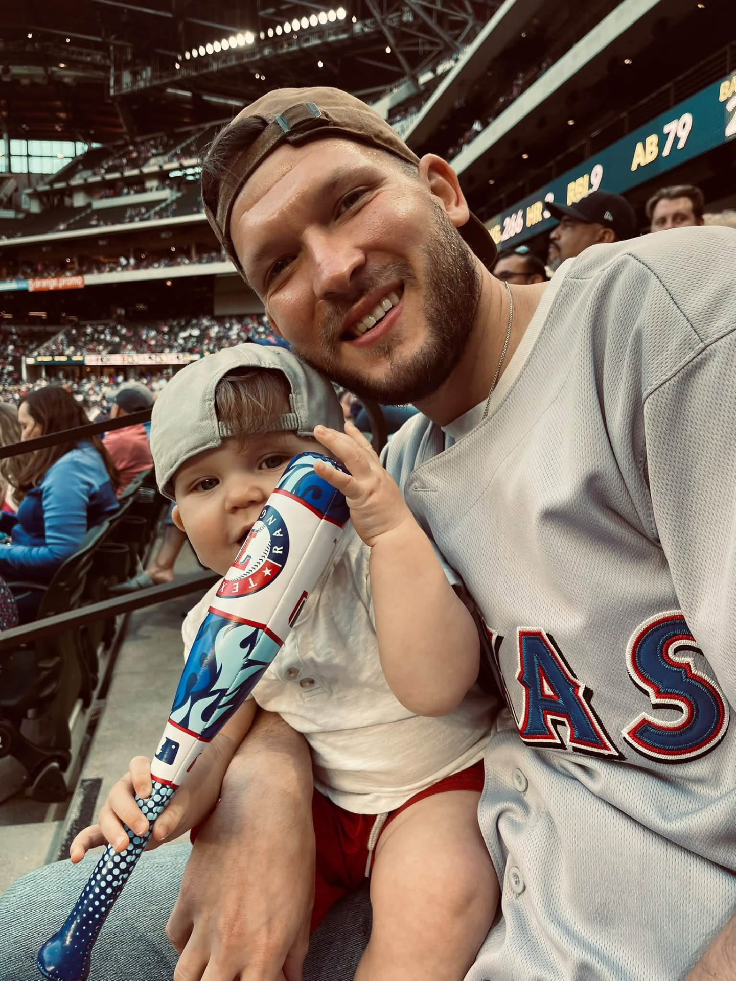 Cody with a young child in the stands at a Texas Rangers baseball game