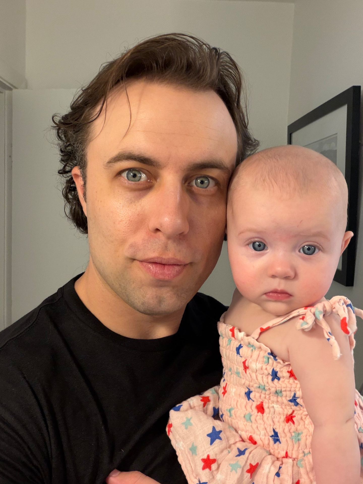 Tom Lail holding a baby close in a softly lit room