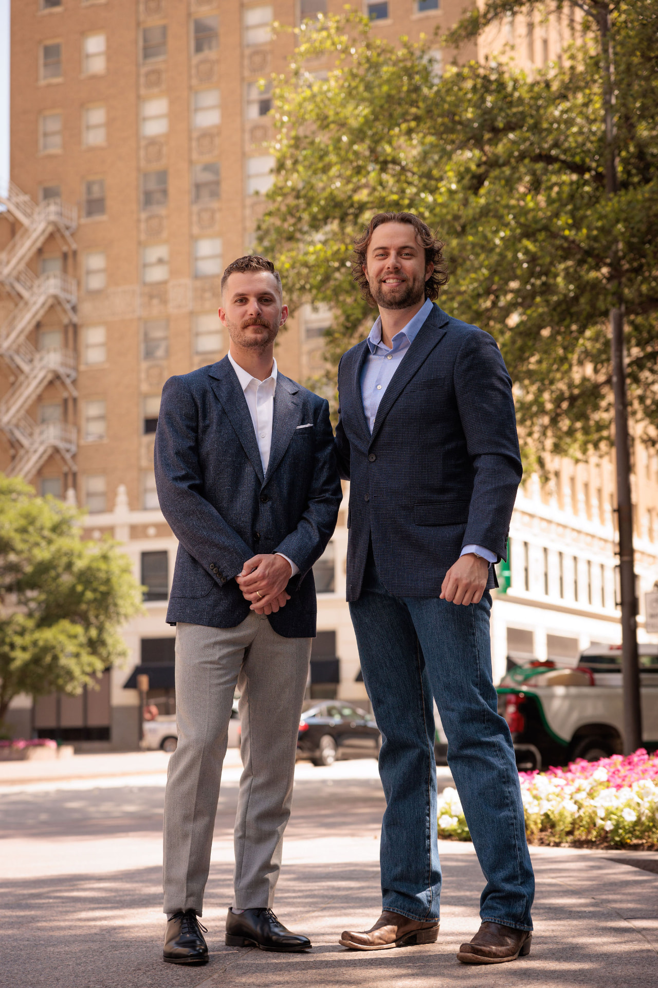 Two TrueGuard property managers in blazers standing on a city street in front of a historic brick building